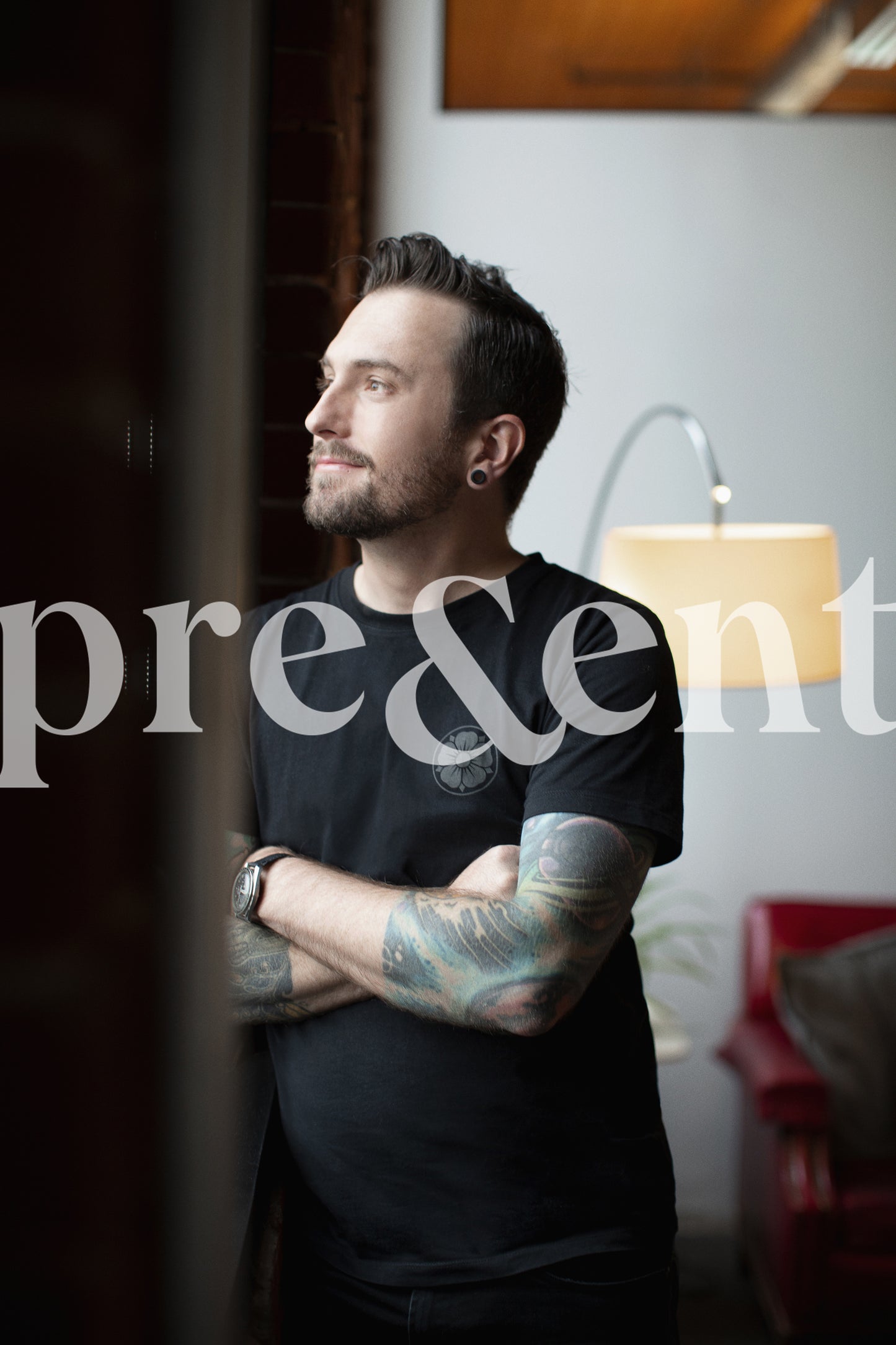 Person with tattoos looking through window