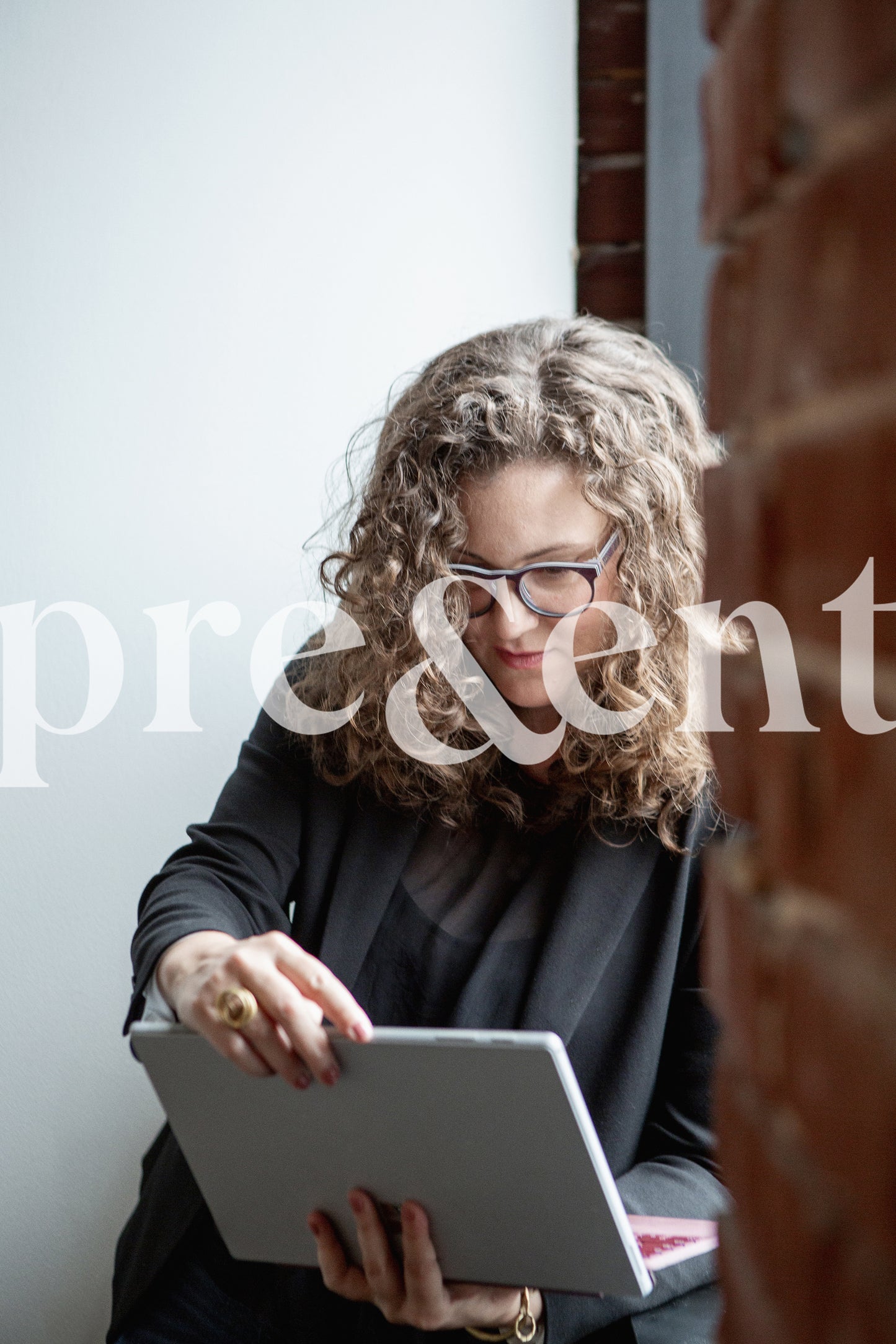 Professional working on tablet by a window