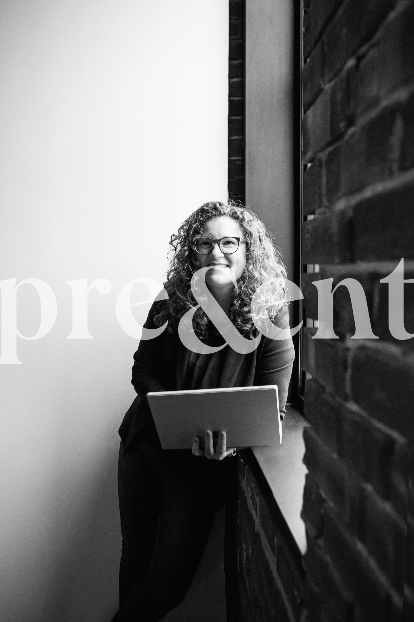 Smiling person reading on tablet next to a window
