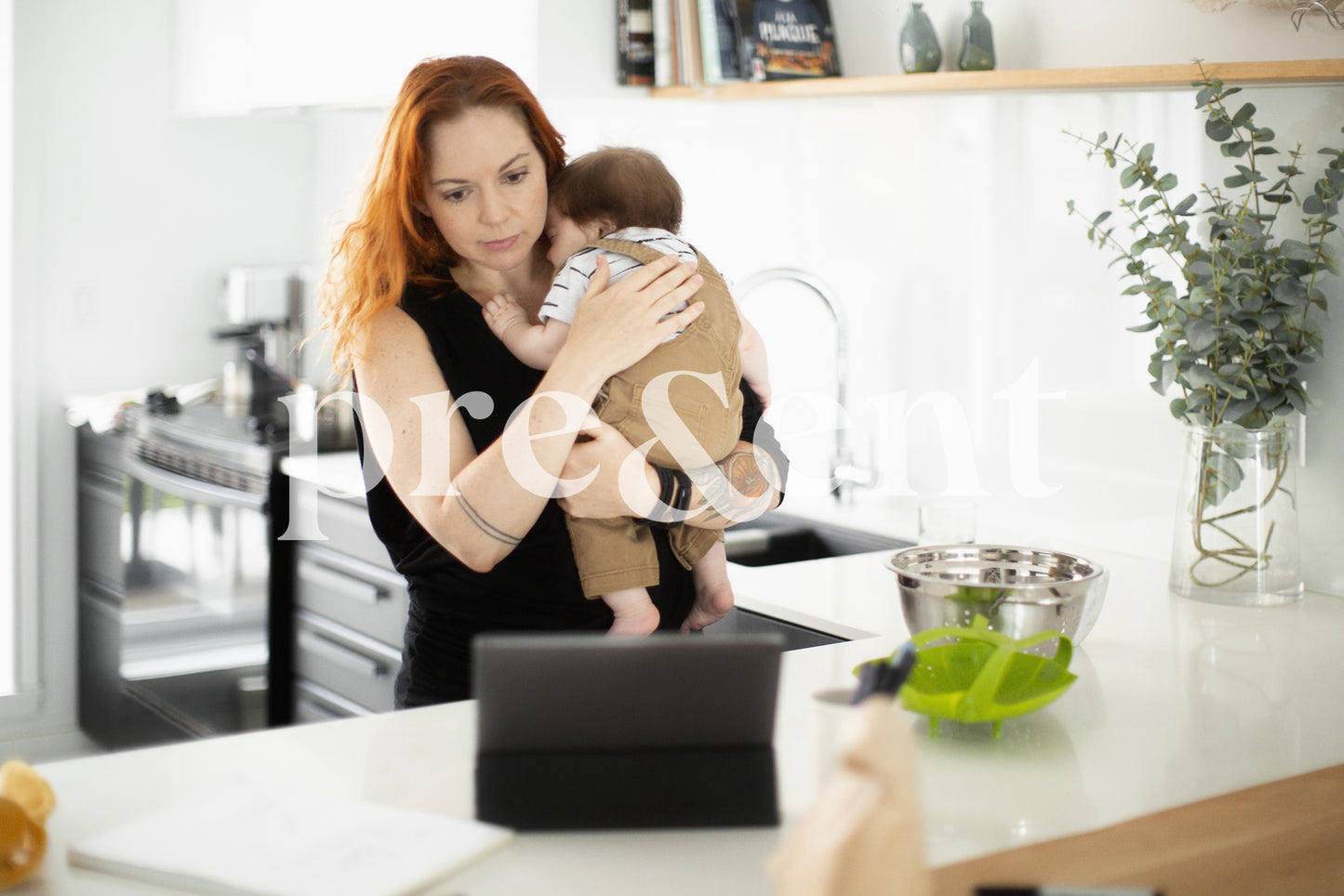 Parent regardant une tablette en tenant un bébé