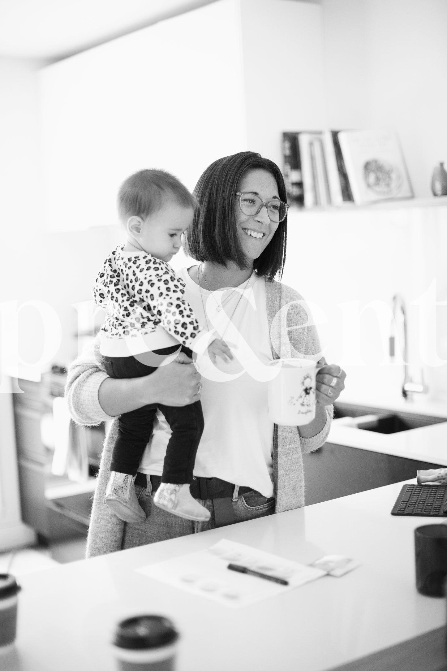 Parent buvant un café en tenant son jeune enfant