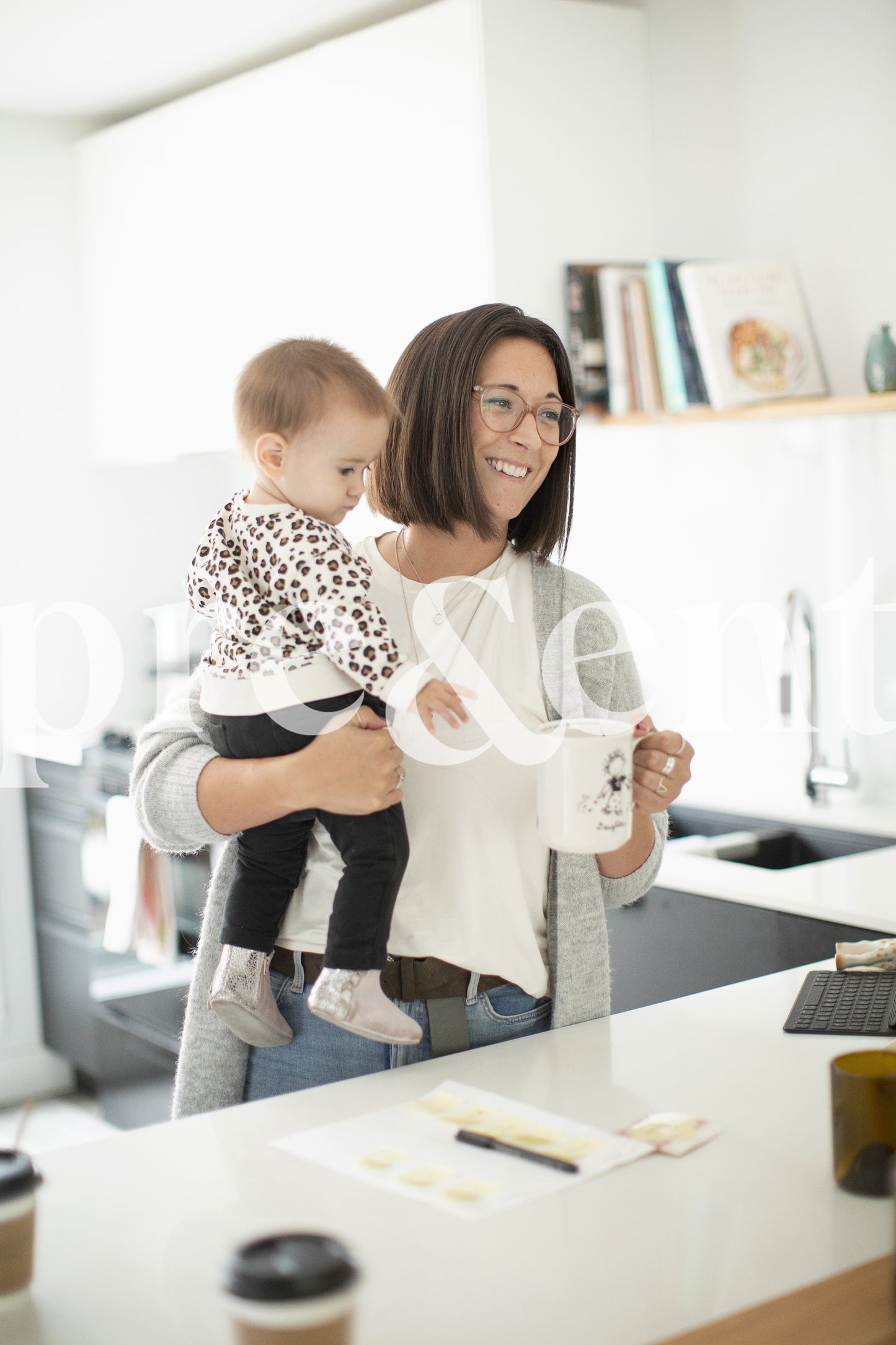 Parent buvant un café en tenant son jeune enfant