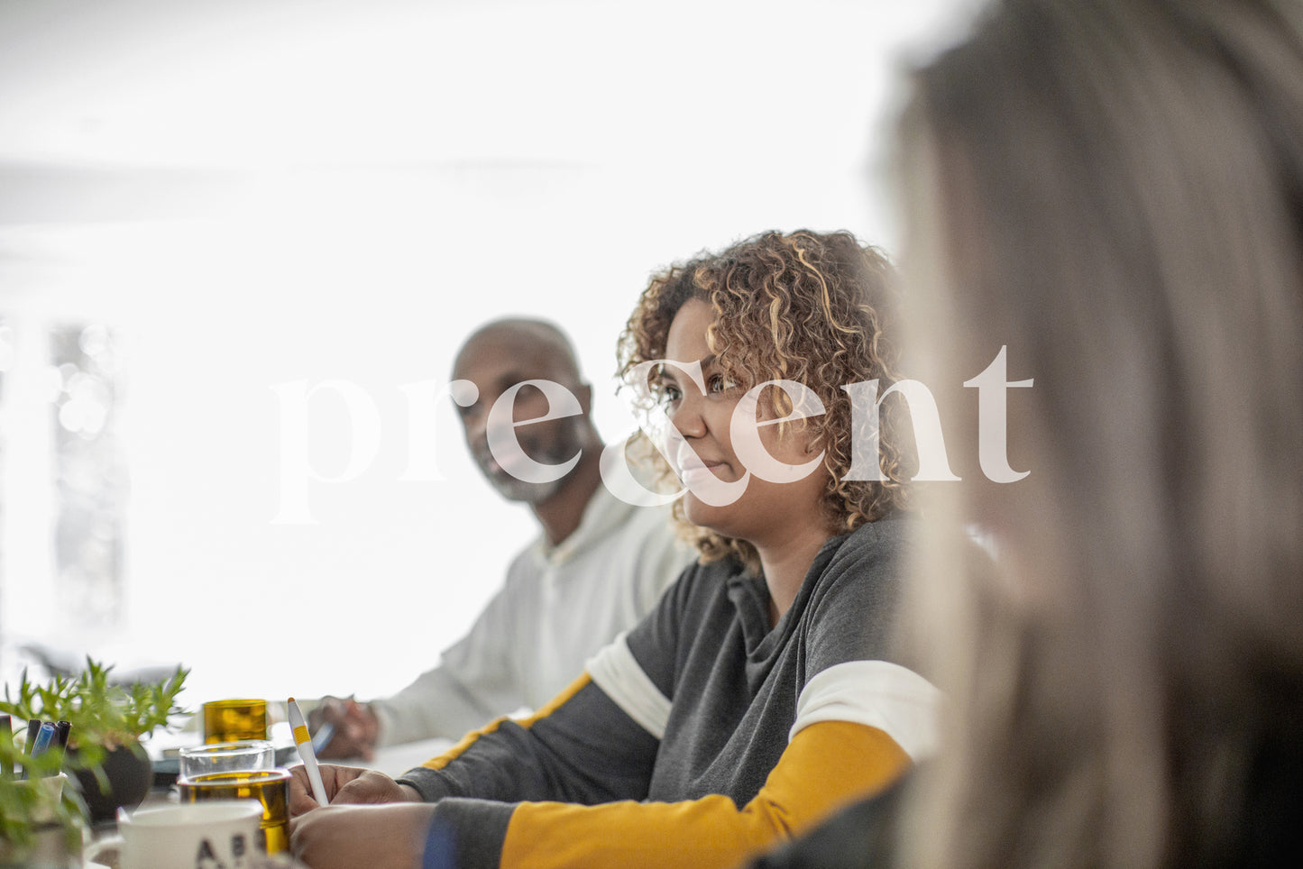 Group sitting at table, looking attentive