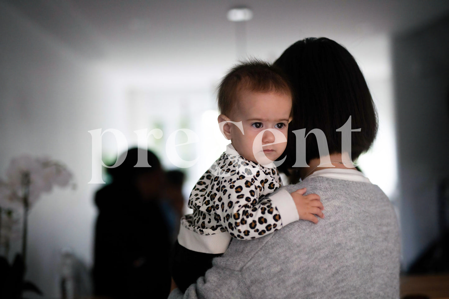 Baby looking serious over their parent shoulder