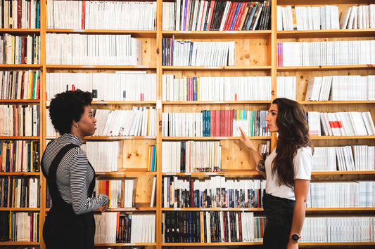 Conversation dans une bibliothèque devant une étagère