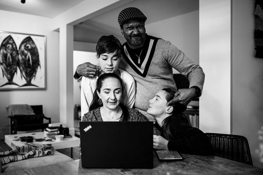 Famille réunie autour d'un ordinateur portable en train de s'amuser