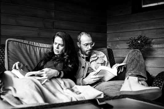 Couple at home reading on their balcony