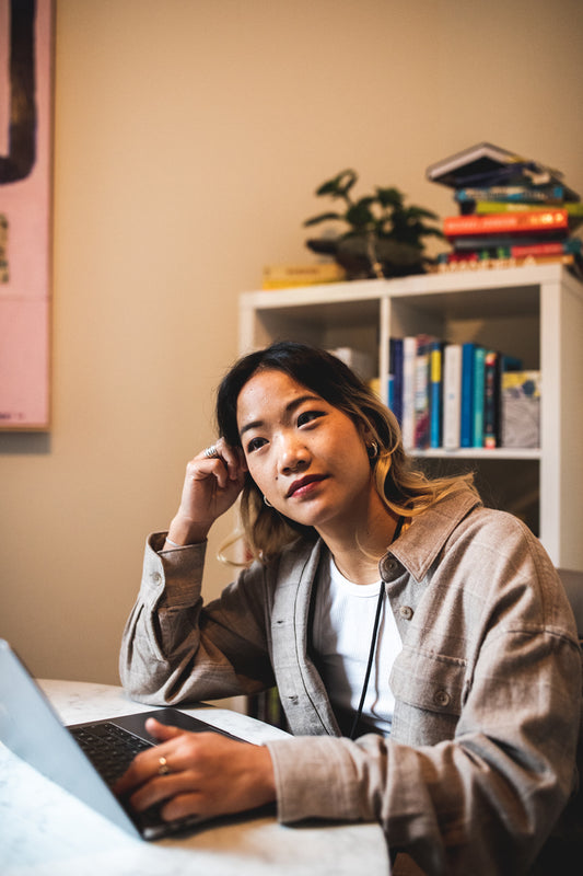 Person thinking while working on a laptop