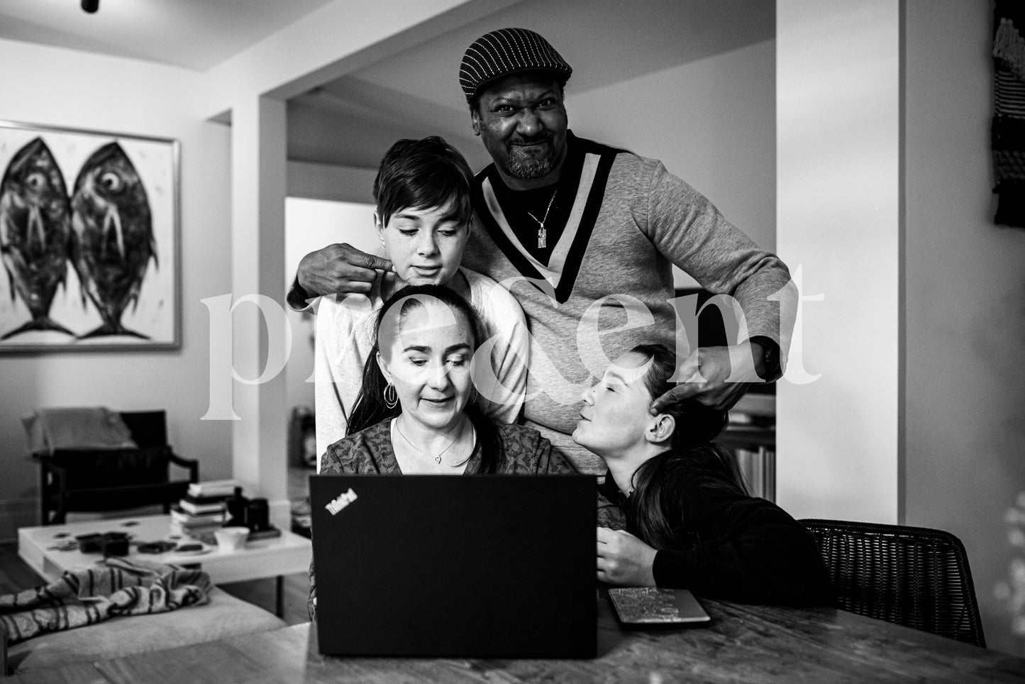 Family gathered around a laptop having fun