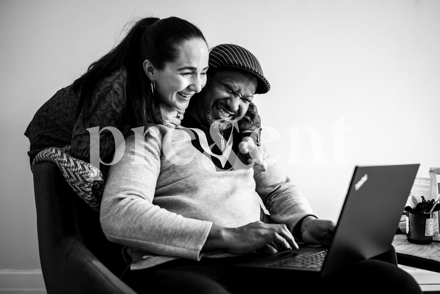 Couple riant devant un écran d'ordinateur portable