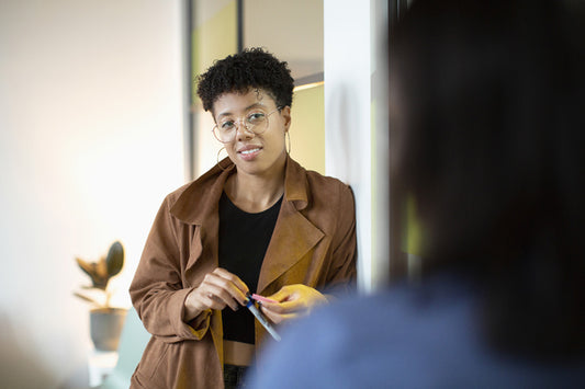 Une personne qui écoute en s'appuyant contre un mur