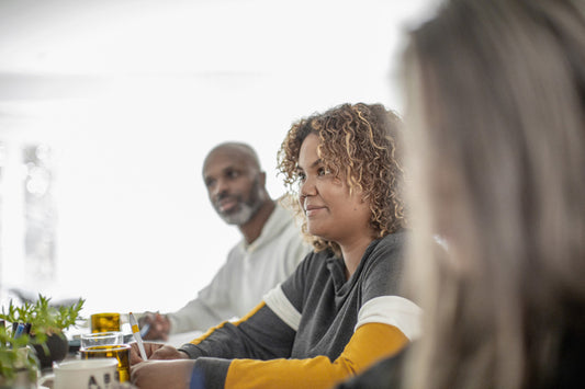 Group sitting at table, looking attentive