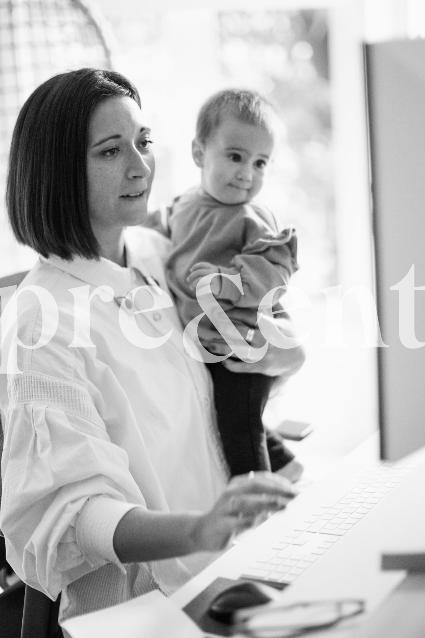 Travailler sur un ordinateur en tenant son enfant