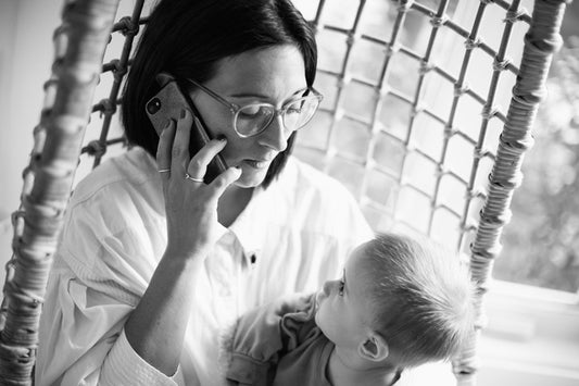 Parent au téléphone en portant son enfant