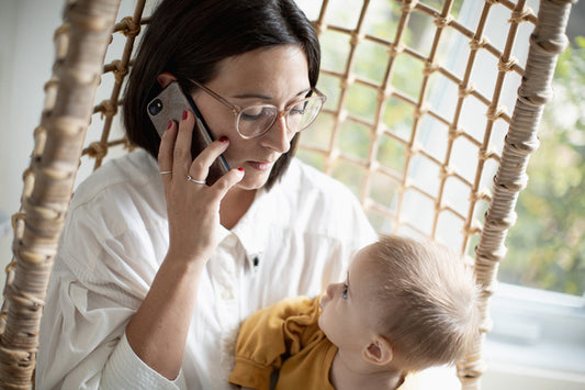 Parent au téléphone en portant son enfant