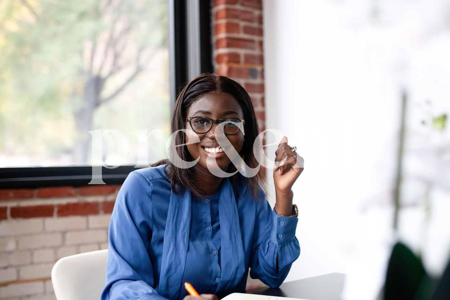 Smiling person with glasses, taking notes