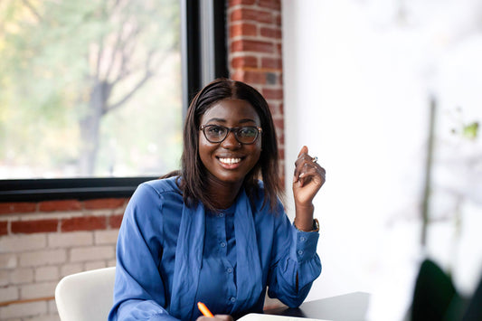 Smiling person with glasses, taking notes