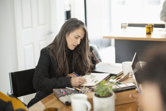 Personne dessinant à table